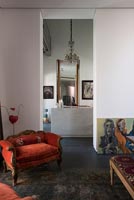 Small orange antique armchair and modern art 