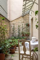 Small courtyard garden with cafe table and chair 
