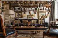 Eclectic country living room with huge display of wooden masks on wall 