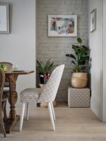 Patterned chair at head of modern dining table 