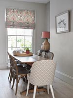 Patterned chair at head of modern wooden dining table 