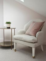Large cushion on armchair with side table 