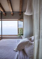 Country bedroom with coastal views through open windows in summer 