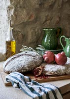 Detail of bread and fruit on country kitchen worktop 