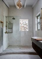 View of exterior stone wall through window in country bathroom - shower 