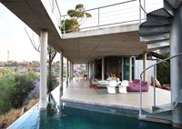 Modern outdoor living area next to infinity pool 