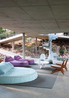 Covered concrete terrace with large beds and seating area