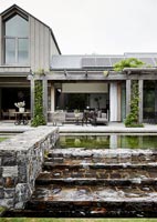 Modern country house exterior with outdoor living area on terrace 