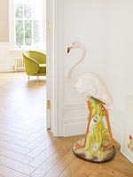 Large ceramic flamingo ornament in hallway 