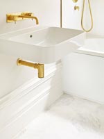 Modern bathroom sink detail with gold taps 