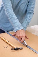 Woman cutting cork board to size - Memories Notice board 