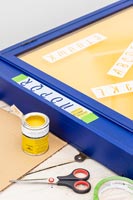 Painting stencil letters on memories notice board 