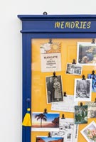 Blue and yellow memories notice board on wall 