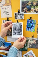 Woman adding photograph to memories notice board 