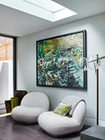 Low cushion chairs and large painting in modern living room