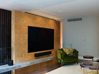 Large wall mounted flat screen television in stone feature wall