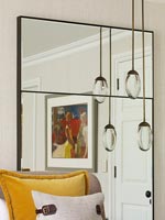 Large mirror with reflection of painting and pendant lights 