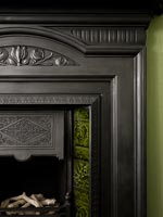 Detail of black fireplace with green inlaid tiles 