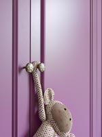 Toy hanging from purple painted wardrobe doors 