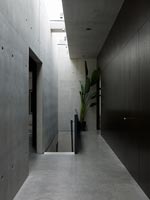 Narrow concrete corridor with view to staircase 