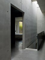 Narrow concrete corridor with view to staircase 