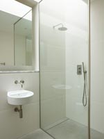 Shower cubicle and sink in modern bathroom 
