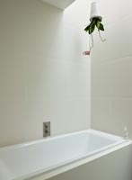 Upturned plant pot over bath in modern bathroom 