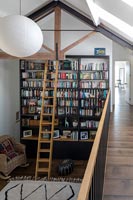Ladder against large wall of bookshelves in reading room 