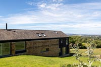 Exterior of modern country house with extensive countryside views beyond 