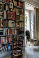 Classic style chair in window next to bookshelves 