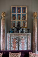 Decorative sideboard with ornaments and painting above 