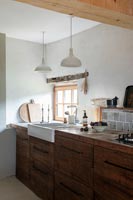 Butler sink set in wooden worktop of modern country kitchen 