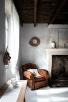Vintage brown leather armchair in white country dining room 