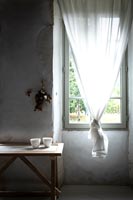 Knotted white curtain over window 