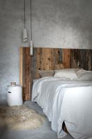 Modern country bedroom with rustic wooden headboard 