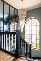 Large chandelier over staircase with stained glass window