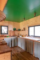 Wooden country kitchen with green painted ceiling 