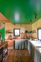 Wooden country kitchen with green painted ceiling