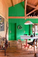 Green painted wooden feature wall in modern country dining room 