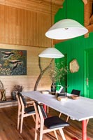 Country dining room with green painted wooden feature wall 