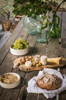 Bread and cheese on rustic outdoor dining table 