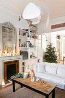 Christmas tree and candles in white country living room 