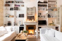 Lit fireplace in white living room at Christmas 