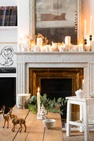 Display of candles on white marble mantelpiece 