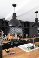 Black brick tiling splashback in modern kitchen 