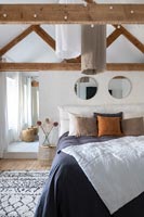 Exposed wooden beams in modern country bedroom 