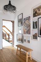 Display of framed pictures on wall with view to mezzanine walkway 