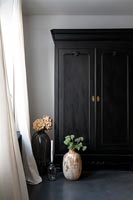 Black wardrobe in white painted bedroom with dark grey flooring 