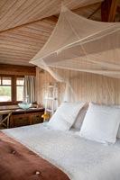 Country bedroom with mosquito net canopy over the bed 