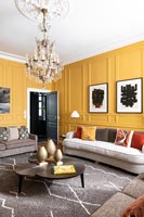 Modern living room with yellow painted panelled walls 